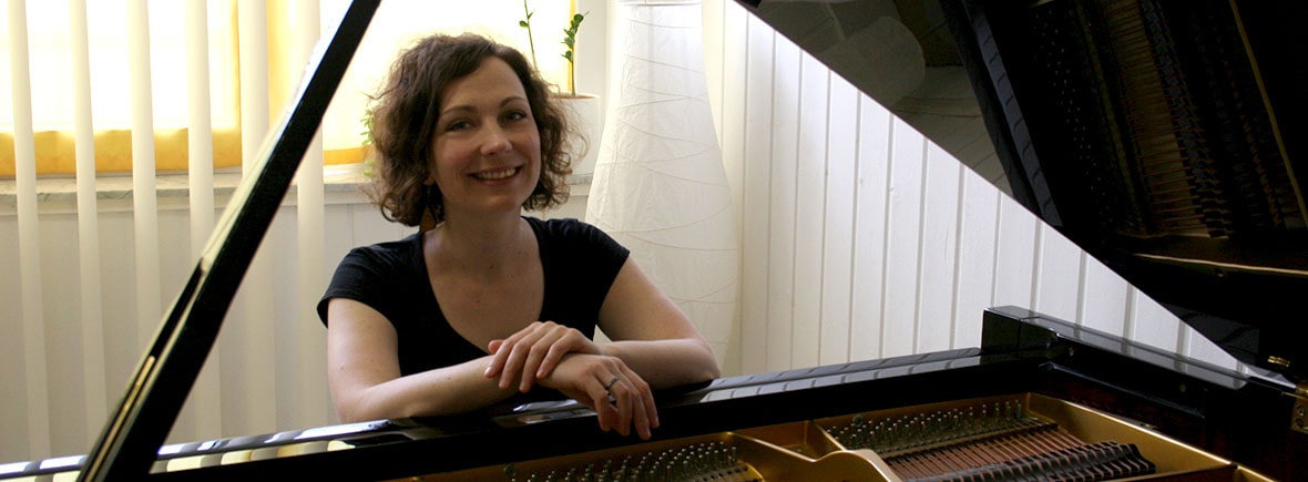 Klavierlehrerin Linda F. Kniep am Klavier. Studium und Lehrtätigkeit. Infos zu Weltmusik